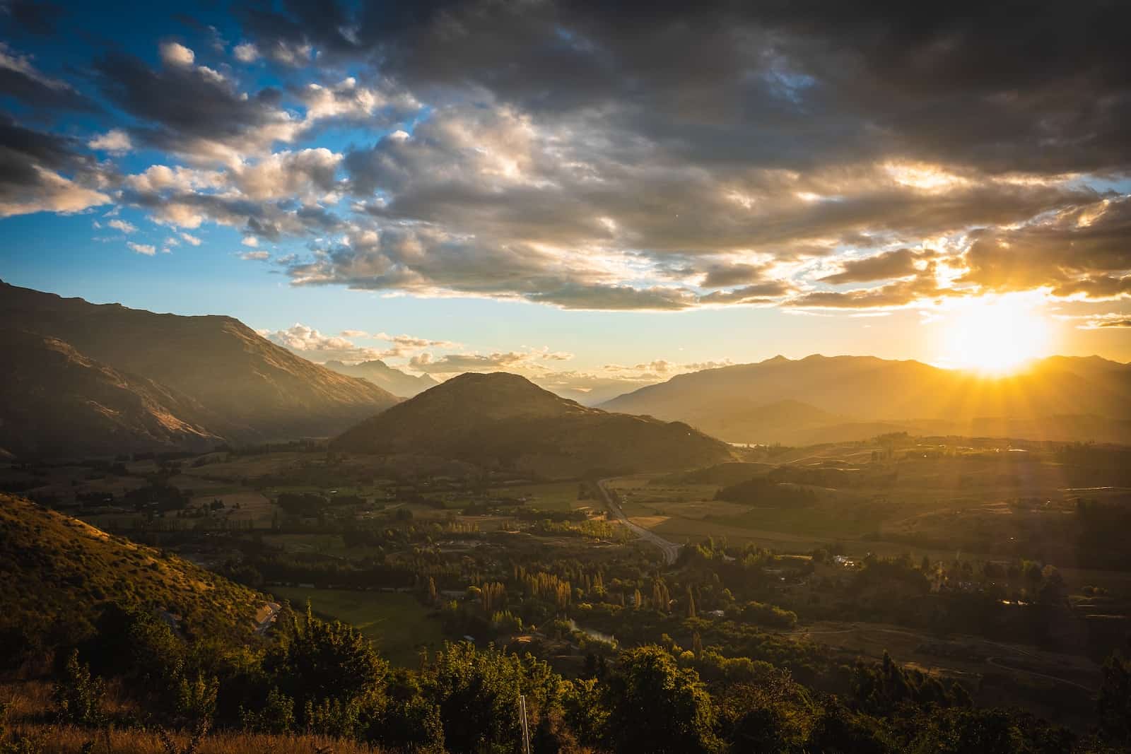 Sunset over a South Island valley, with ranges silhouetted against a golden sky